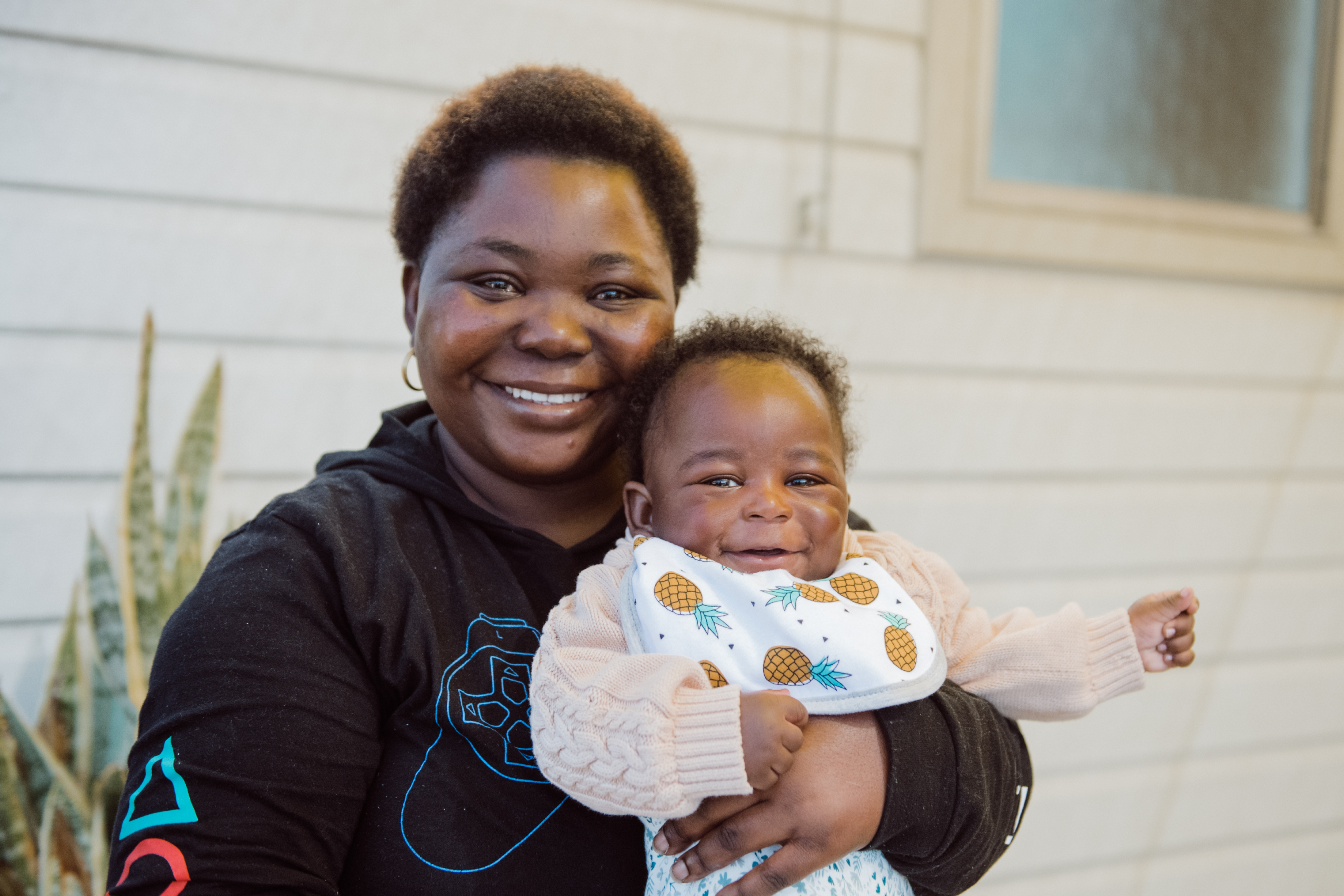 Photo of a community member holding a baby at Zara's House