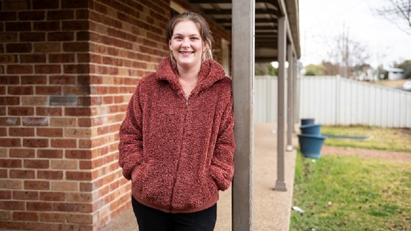 Kim facing the camera while she leans against a pole
