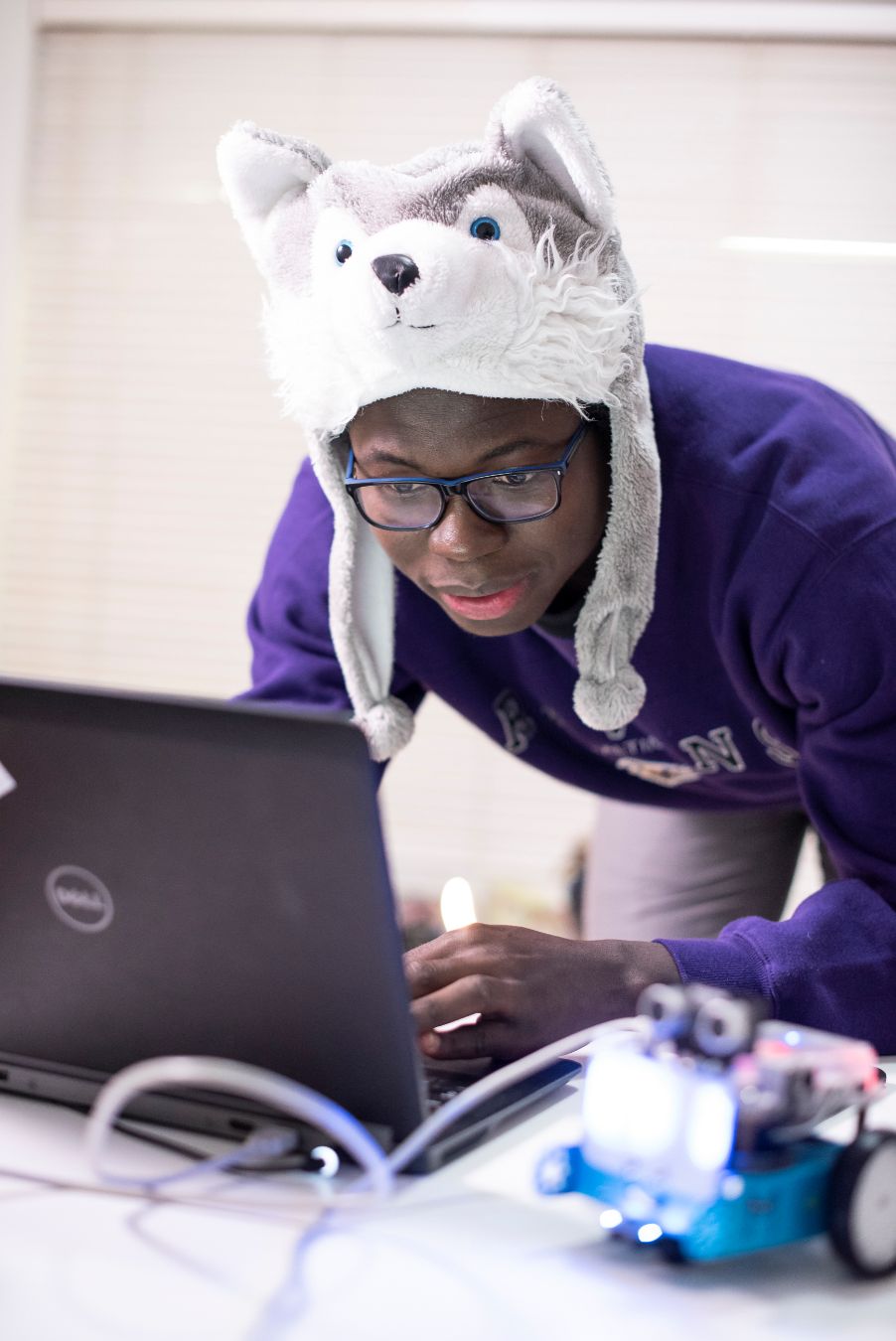 Daniel pictured lent over, using his laptop