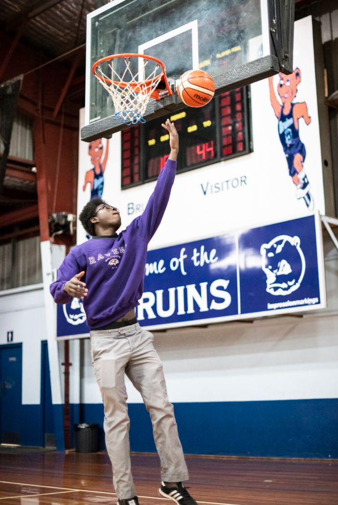 Daniel shooting a basketball into the hoop. 