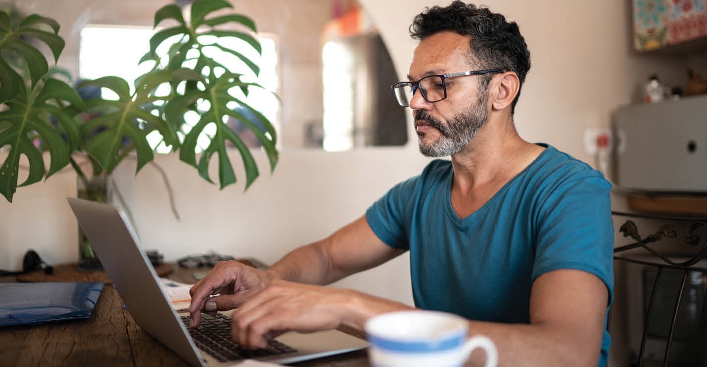 An Aboriginal man browses the resource centre using his laptop. 