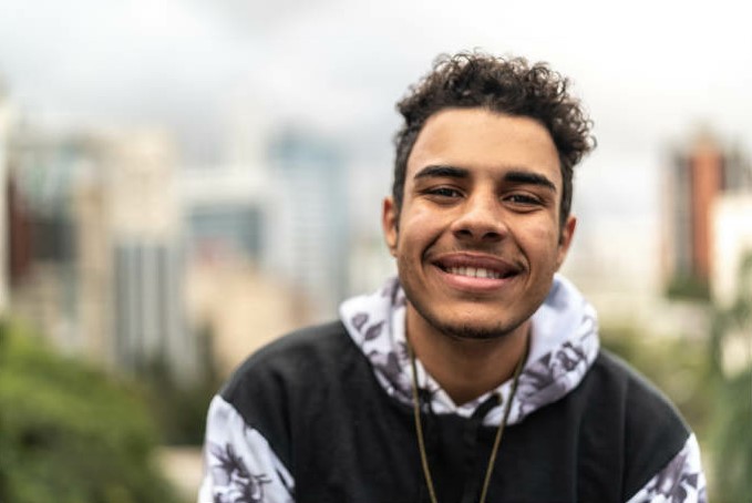 A young person smiles at the camera